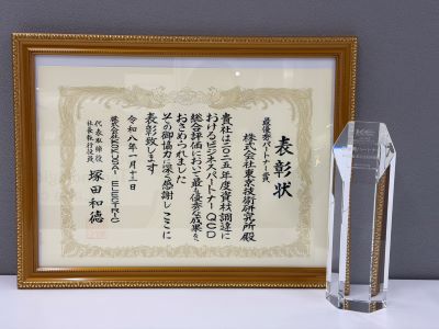 額に入った最優秀パートナー賞の表彰状と、透明な記念の盾