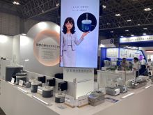ガラス器具用マントルヒーターや収縮チューブ用ヒーターを並べた展示台と、大型ディスプレイ